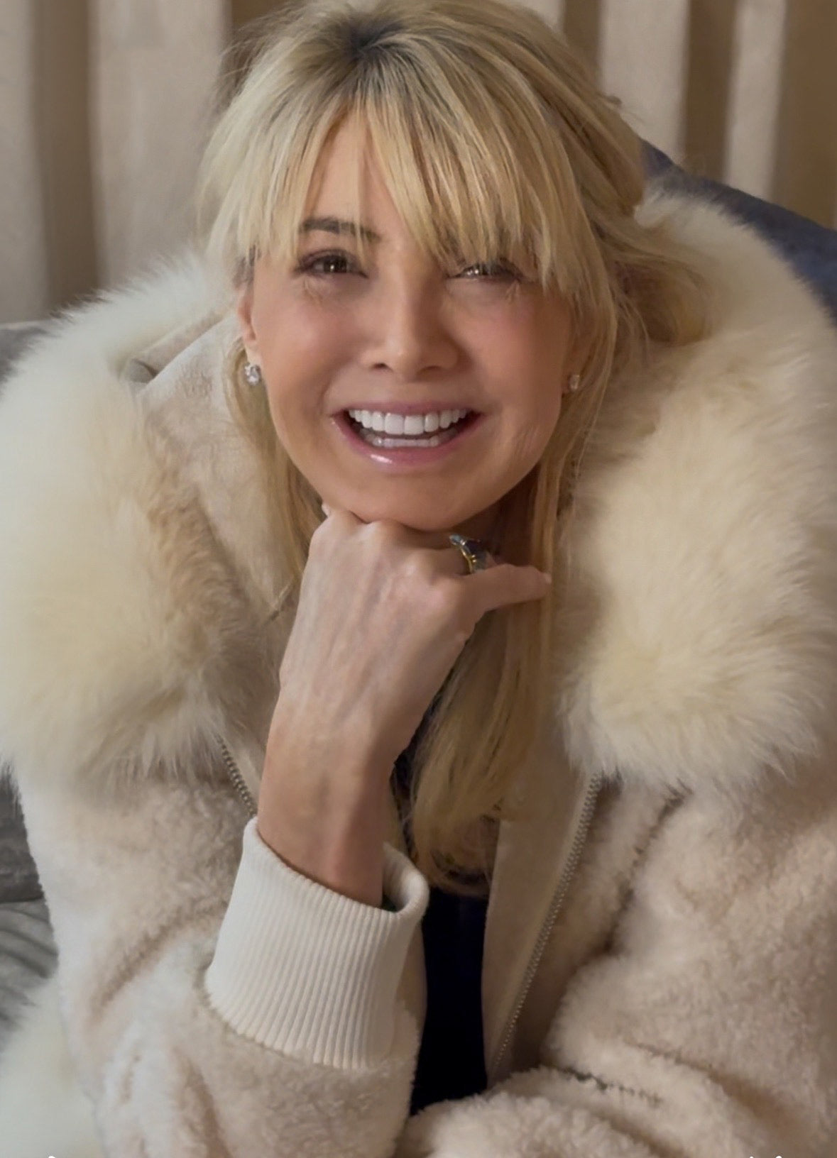 Nancy Ganz wearing a fur coat with a neutral background 